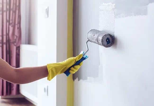 Applying moisture-resistant paint on bathroom walls to prevent mold and humidity damage