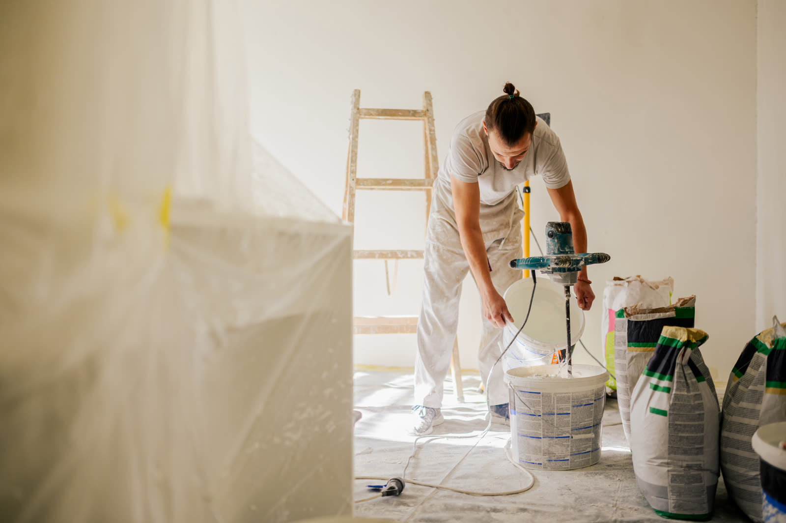 A laborer is adding water to a plaster mixture whi — the kind of drywall repair & patching our vetted local pros handle in Sarasota, FL