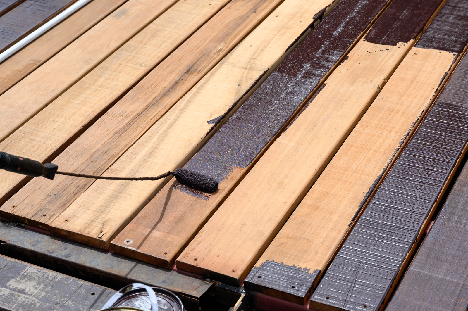 worker painting with paint roller on wood floor — Painting (Interior & Exterior) in Sarasota, FL
