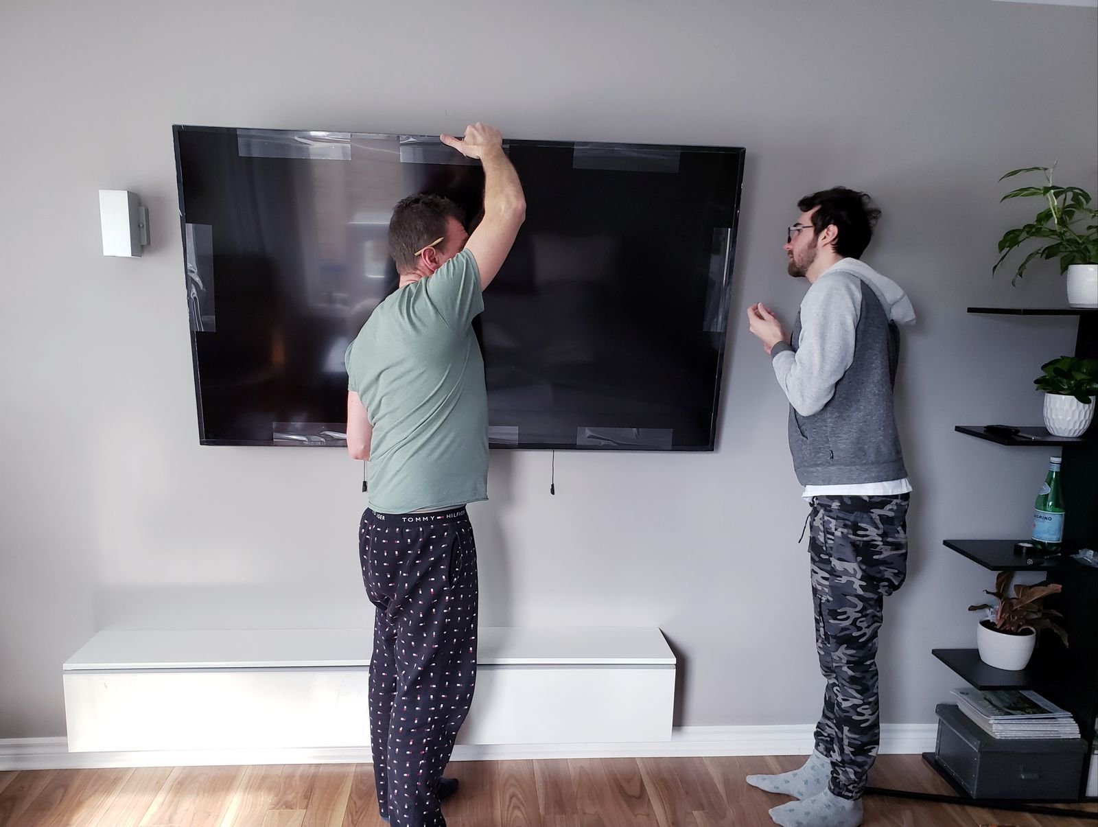 Hanging a large TV, two sets of hands — the kind of work our vetted local pros handle in Sarasota, FL